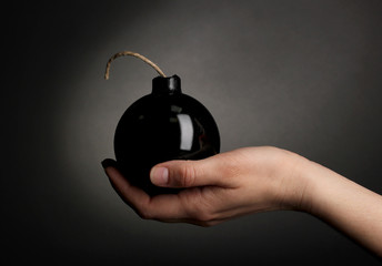 Cartoon style bomb in hand on black background