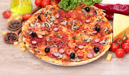 delicious pizza and vegetables on wooden table