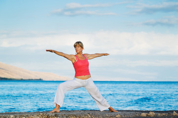 Beautiful Yoga woman Practicing Yoga by the Ocean