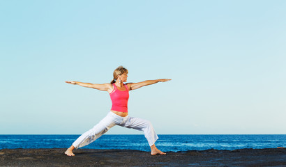 Obraz premium Beautiful Yoga woman Practicing Yoga by the Ocean