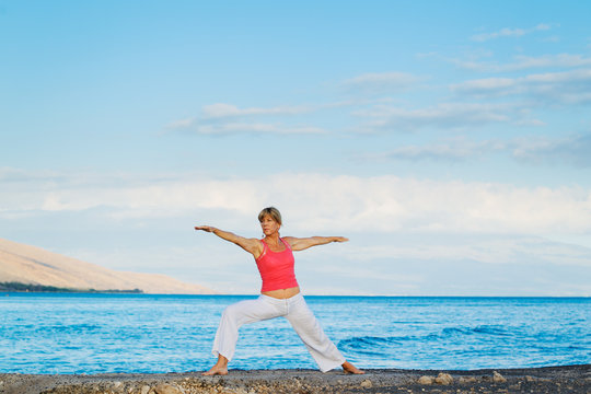 Beautiful Yoga woman Practicing Yoga by the Ocean
