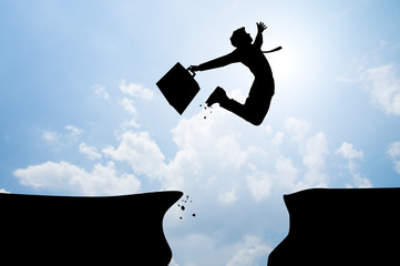 bussiness man jumping over the mountains