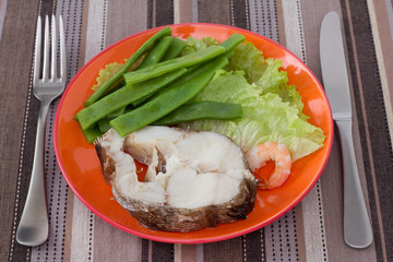 boiled fish with beans and lettuce on the plate