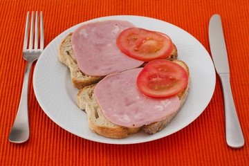 toasts with ham and tomato on the plate