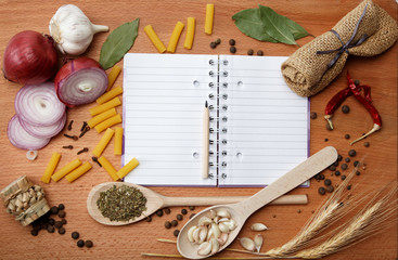 notebook for recipes and spices on wooden table