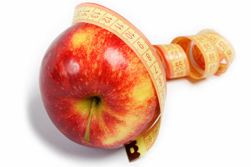 Red apple and measuring tape on a white background.