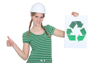 Female construction worker with a recycle sign