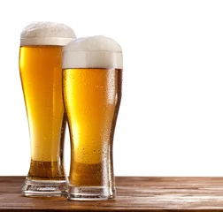 Poster Twee glazen bier op een houten tafel. © volff