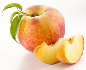 Ripe peach fruit with leaves and slises