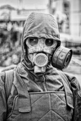 man in gas mask on industrial background