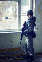soldier in mask on patrol near window