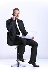 Business man on cell phone in front of laptop