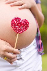 Mulher grávida com pirulito coração