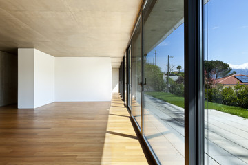 modern concrete house with hardwood floor, large windows