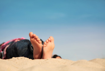 Kind liegt im Sand und erholt sich