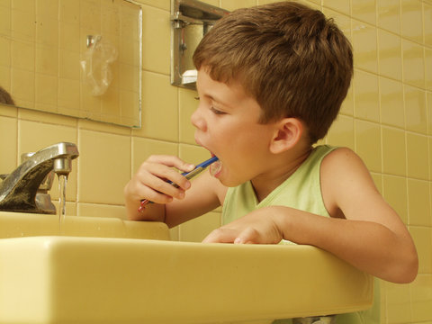 Ni&ntilde;o cepill&aacute;ndose los dientes en un ba&ntilde;o.