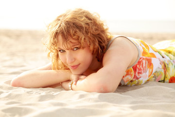 Mädchen liegt im Sand und entspannt sich