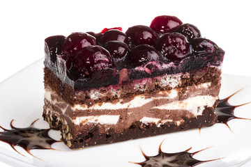 Chocolate cake with cherry on top on a white background