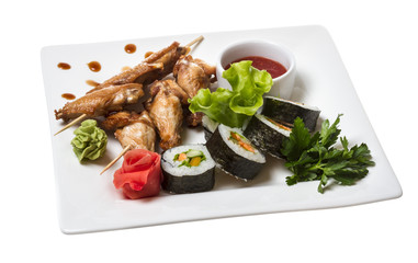 Buffalo chicken wings on plate with sushi