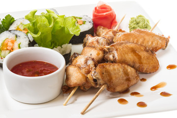 Buffalo chicken wings on plate with sushi