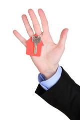Fototapeta premium Key with house-shaped charm in hand isolated on white