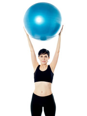 Beautiful woman holding pilates ball