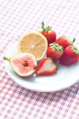 lemon, fig and strawberries on a plate