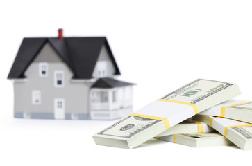 Bundles of dollars in front of house architectural model