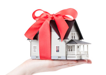 Hand holding house model with red bow - 41560326