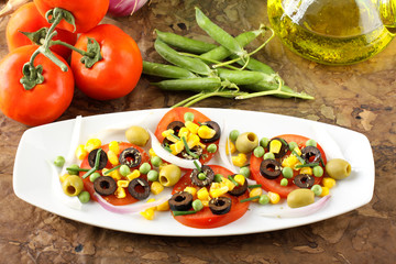 Salad of tomato, olives, corn and peas