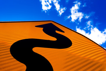 Wavy arrow on road sign pointing up for success