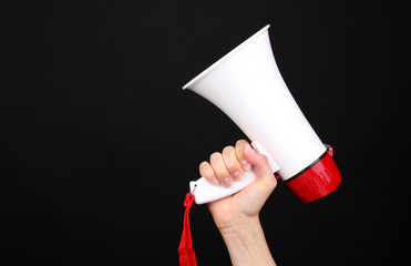 red and white megaphone in hand isolated on black