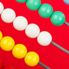 Close-up of an abacus on a red background