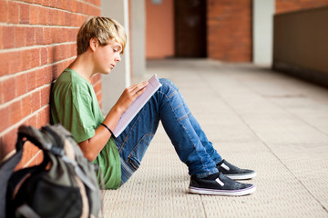 teen high school student reading book in school passage