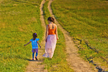 Fototapeta premium mother, woman and little girl my daughter go on rural road throu