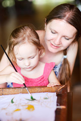 Mother and daughter painting a batik