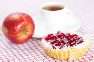 beautiful cake with berries,apple and tea on plaid fabric