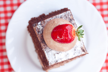 beautiful cake with strawberry on plaid fabric