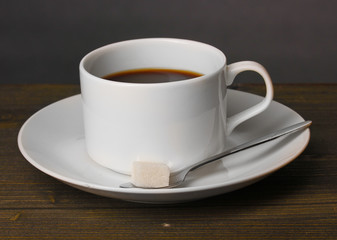 Coffee cup on wooden table on grey background