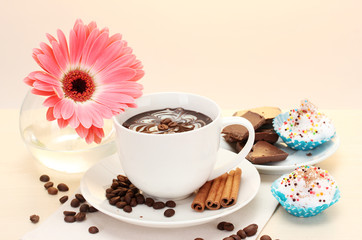 cup of coffee and gerbera, beans, cinnamon sticks