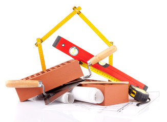 bricks, mason tools and construction plans