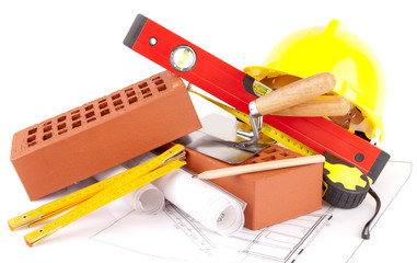 bricks, yellow hard hat, tools and construction plans