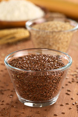 Brown flax seeds in glass bowl with sesame and flour