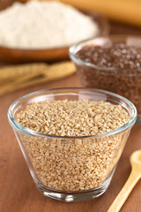 Sesame seeds in glass bowl with flax seeds and flour