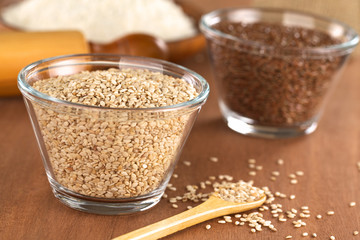 Sesame seeds in glass bowl with flax seeds and flour