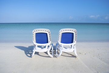 EMPTY BEACH CHAIRS IN FRONT OF OCEAN