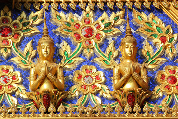 Fototapeta na wymiar Golden Buddha statue in the temple wall.