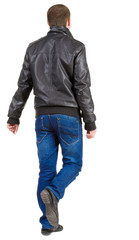 Back view of walking handsome man in jacket.