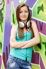 Style teen girl with sunglasses near graffiti background.