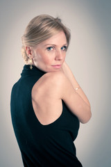 Seductive blonde caucasian woman with elegant black dress.